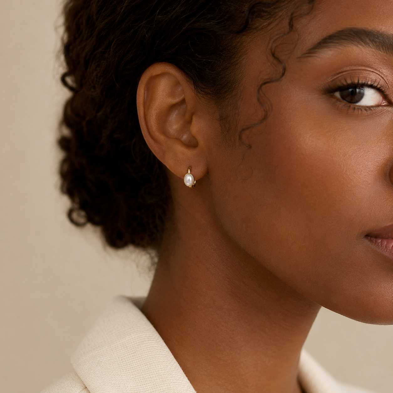 Gold pearl huggie earrings styled on model for an elegant everyday look