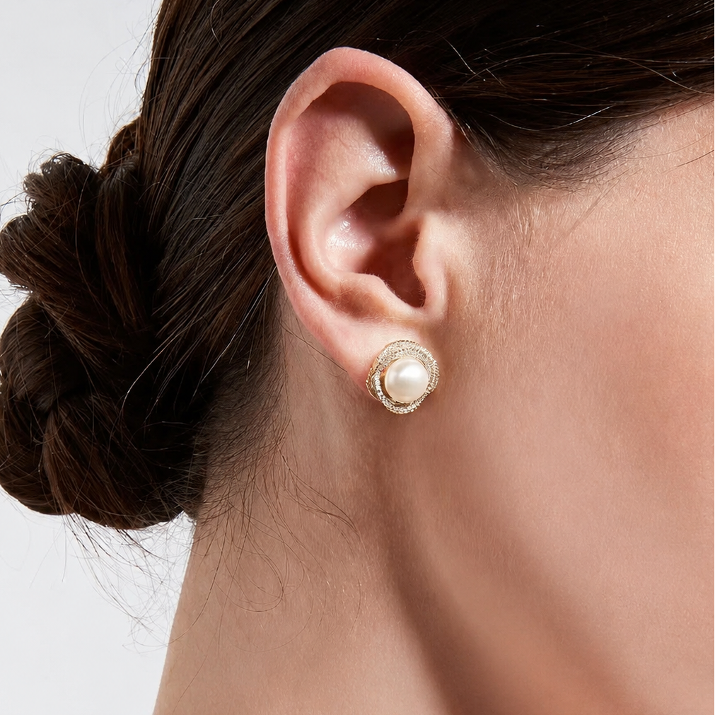 Close-up of model wearing gold pearl halo stud earrings