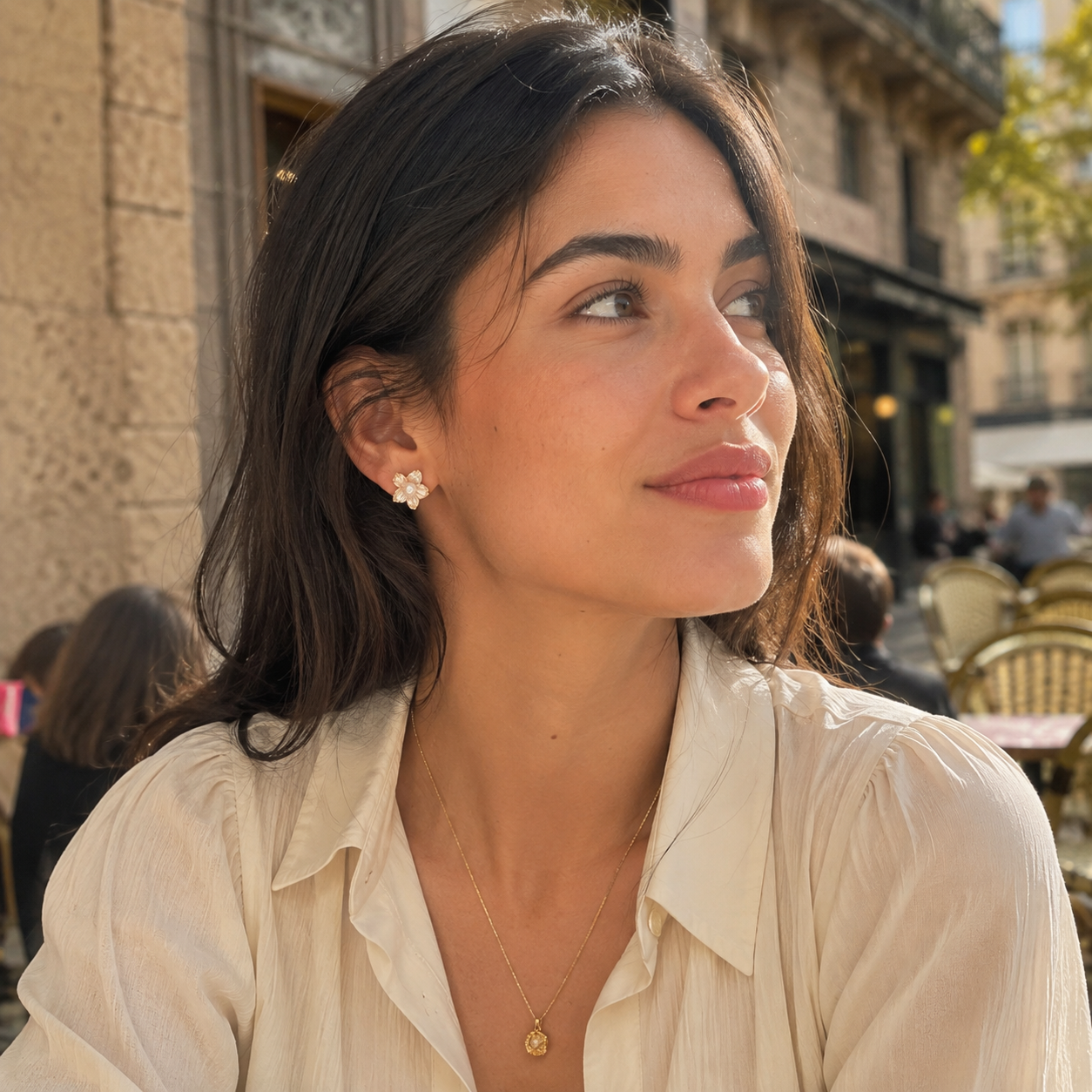Model wearing sculptural pearl blossom earrings with a relaxed white blouse
