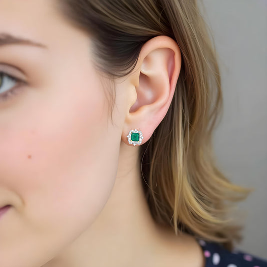 Model wearing Aeterna Jewelry emerald princess cut halo stud earrings, close-up ear view showing square green gemstone with brilliant white accents