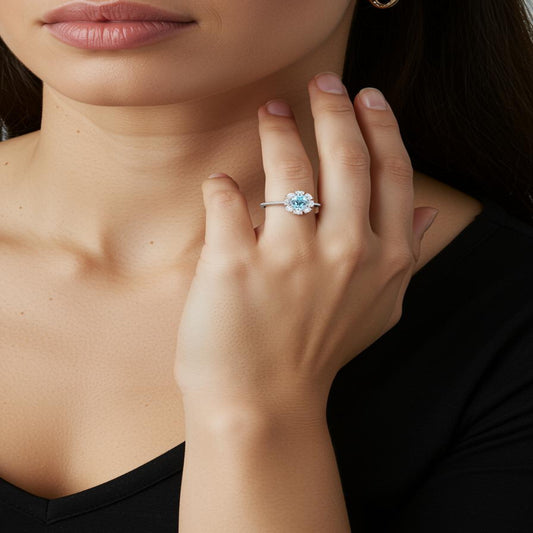 Aeterna Jewelry aquamarine halo ring worn by model, elegant close-up of hand and neckline