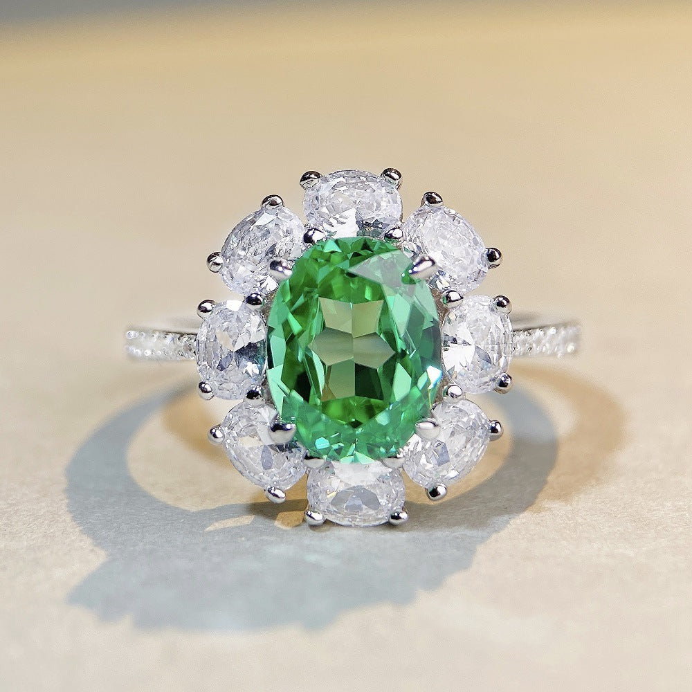 Close-up of Aeterna Jewelry Paraiba tourmaline ring under warm light, showing vivid green brilliance and intricate details