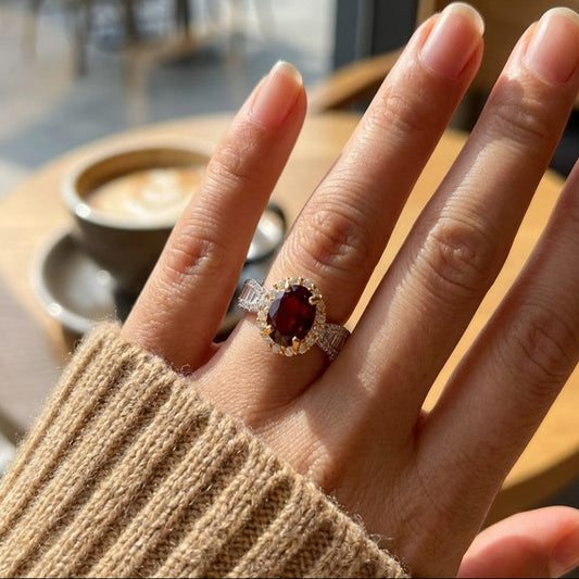 Garnet halo ring worn on hand in cosy café setting