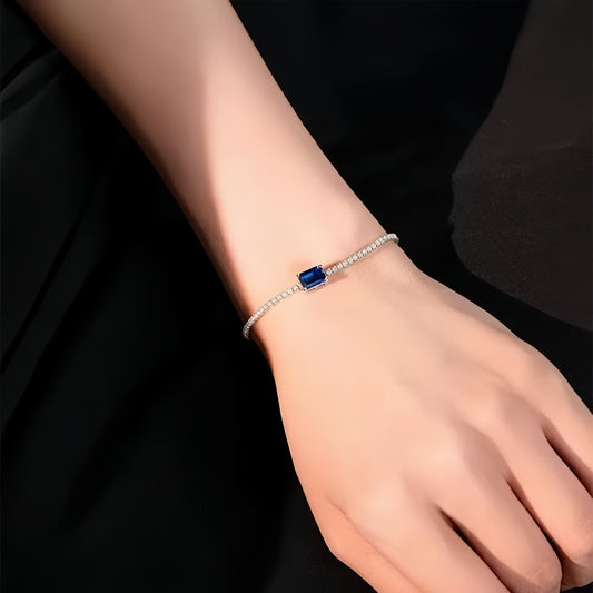 Model wearing sapphire solitaire bracelet by Aeterna Jewelry in elegant setting