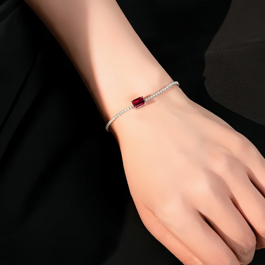 Ruby solitaire bracelet on wrist under soft light, minimal and refined