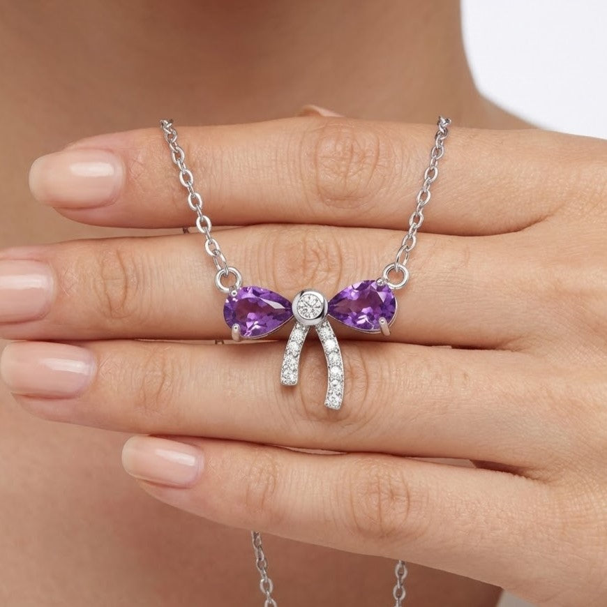 Close-up of amethyst bow pendant necklace with silver chain