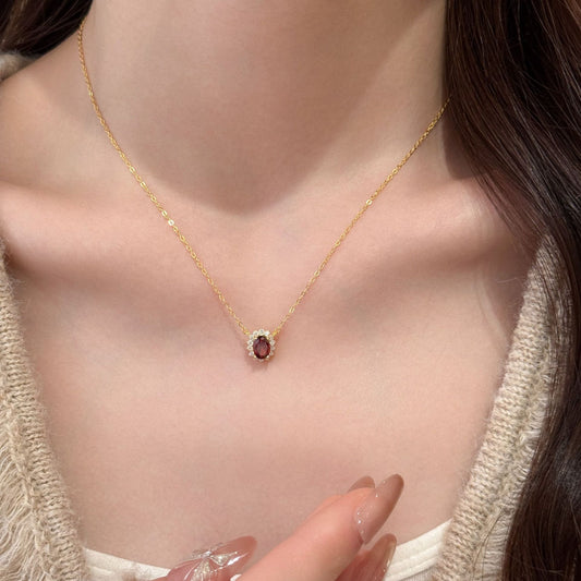 Elegant garnet halo necklace on model, January birthstone jewellery in gold finish