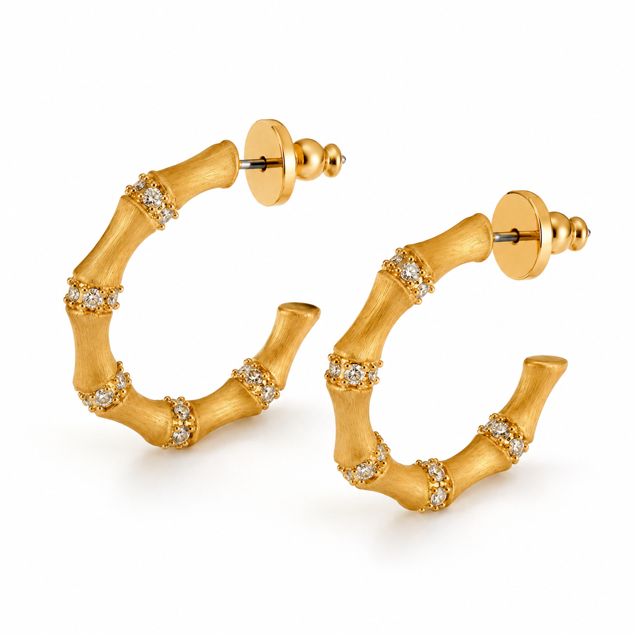 Angled view of gold bamboo hoop earrings on white background