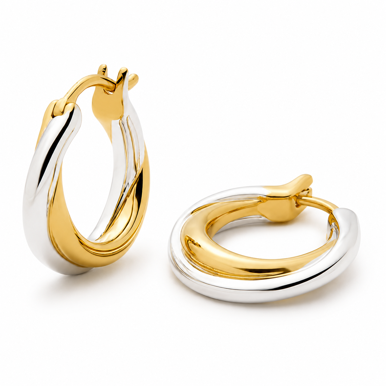 Close-up product image of sculpted two-tone hoop earrings in gold and silver with a polished finish on a white background