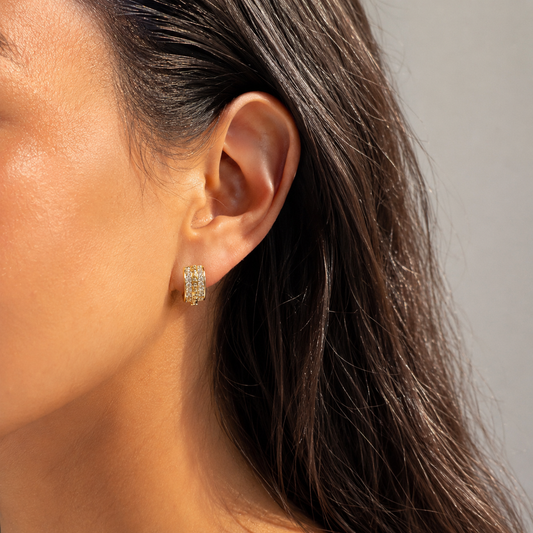Model wearing gold pavé beaded huggie earrings in a close-up ear detail shot