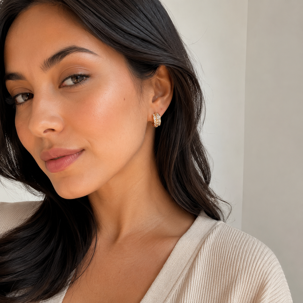 Model wearing gold pavé beaded huggie earrings with a refined everyday outfit