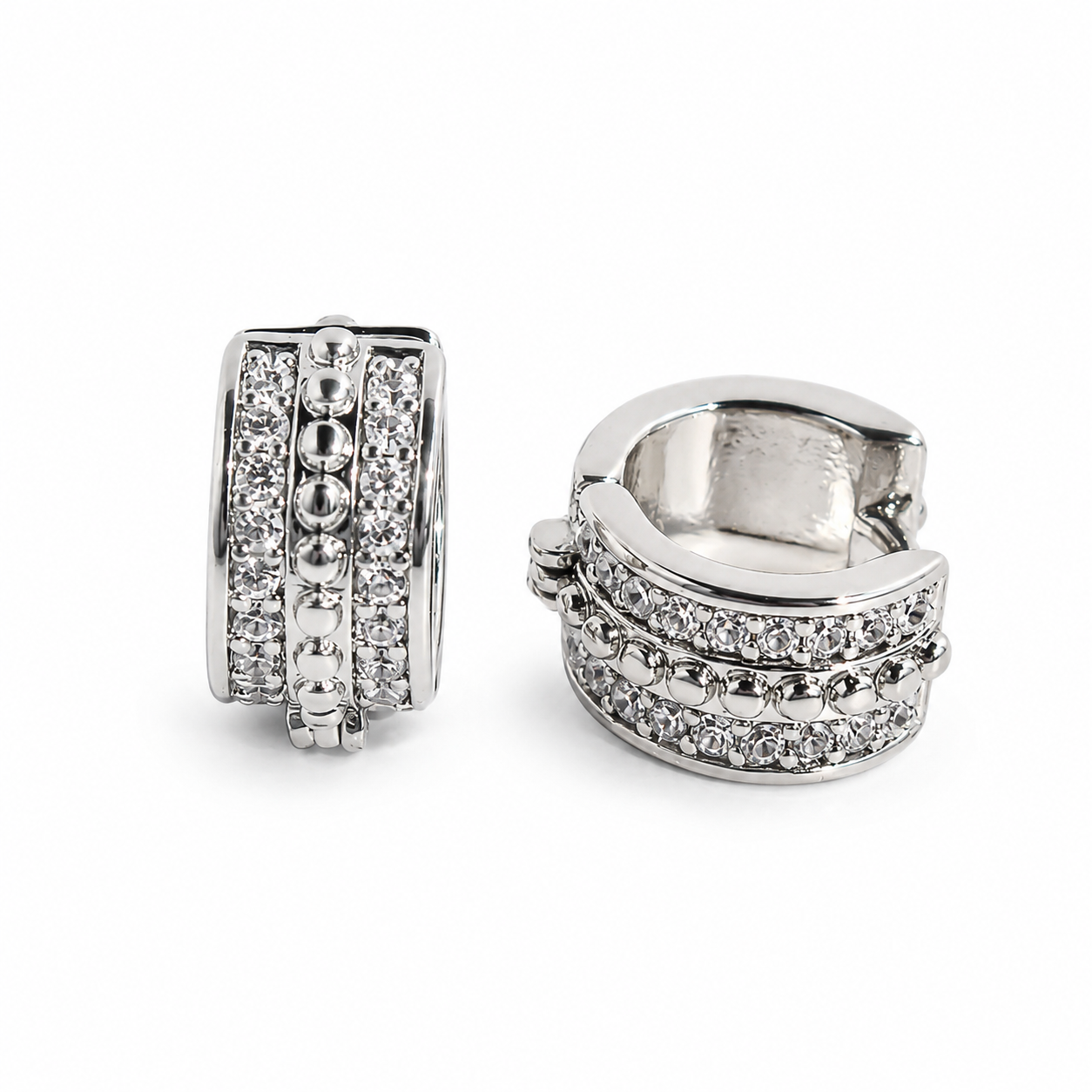 Silver pavé beaded huggie earrings with clear stones on a white background