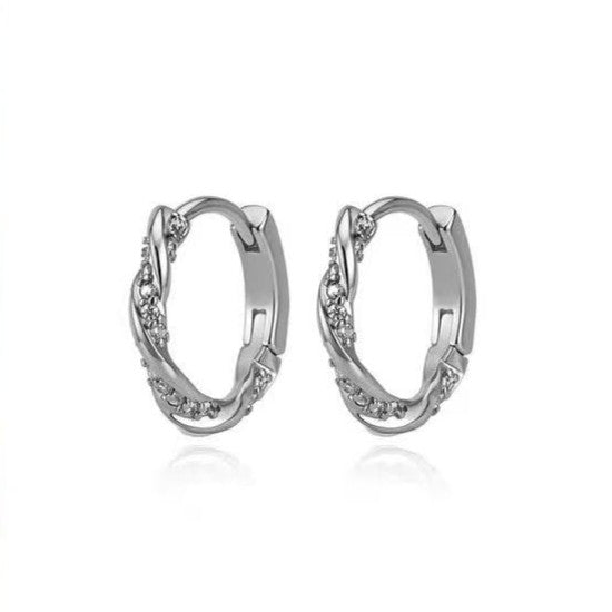 Silver twist pavé huggie hoop earrings on white background
