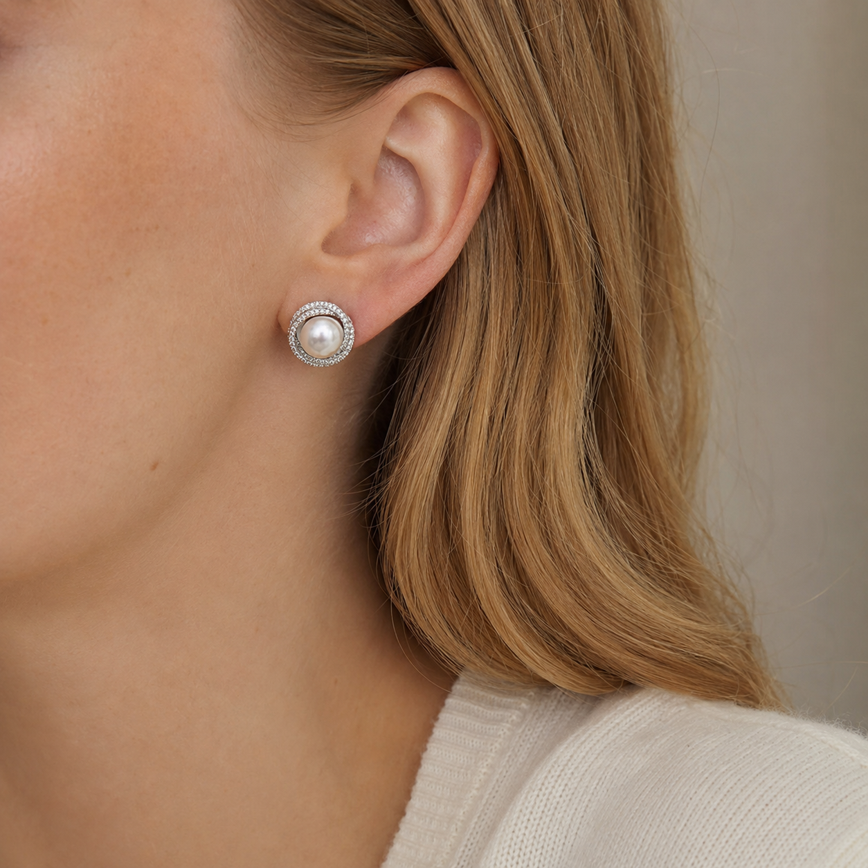 Close-up of model wearing silver pearl halo stud earrings