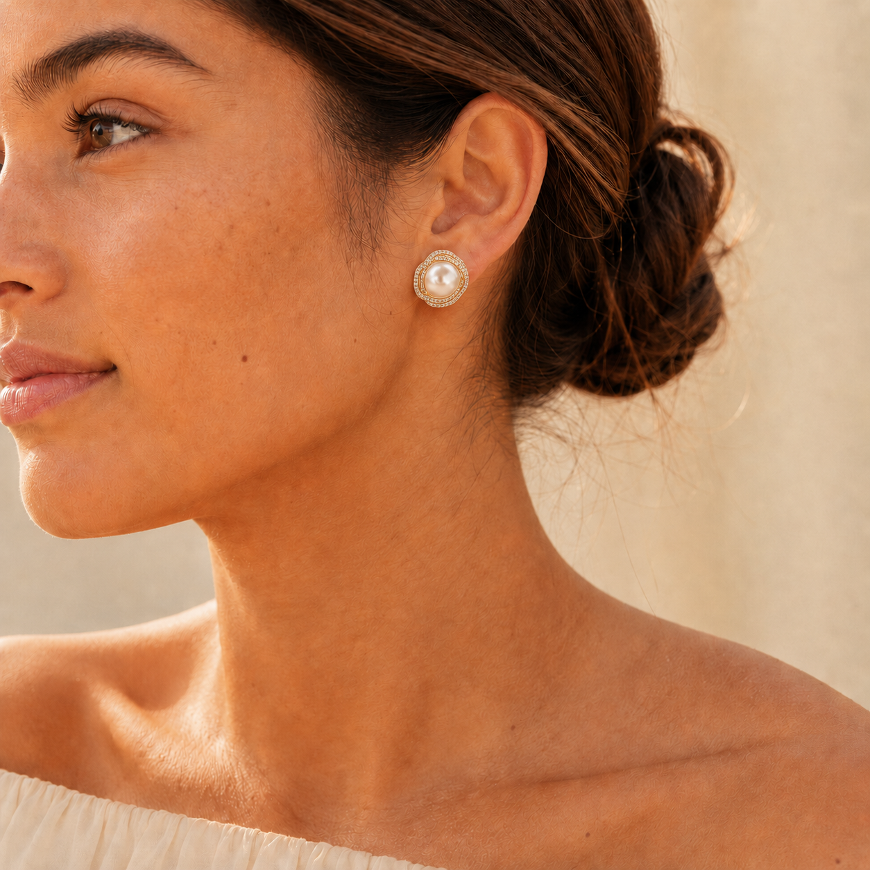 Model wearing gold pearl halo stud earrings in warm natural light