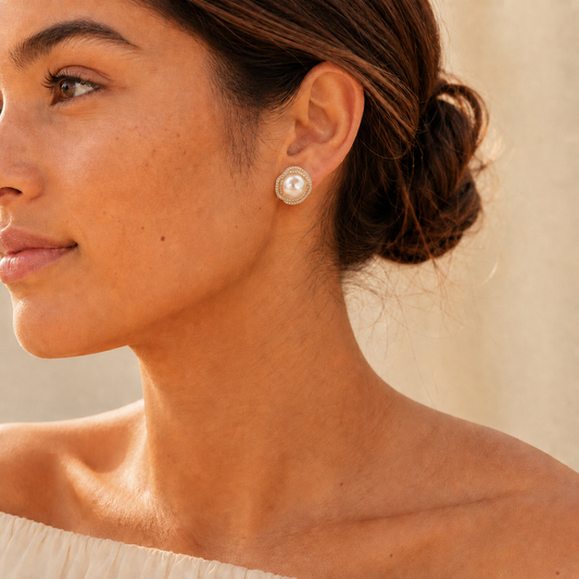 Model wearing gold pearl halo stud earrings in warm natural light