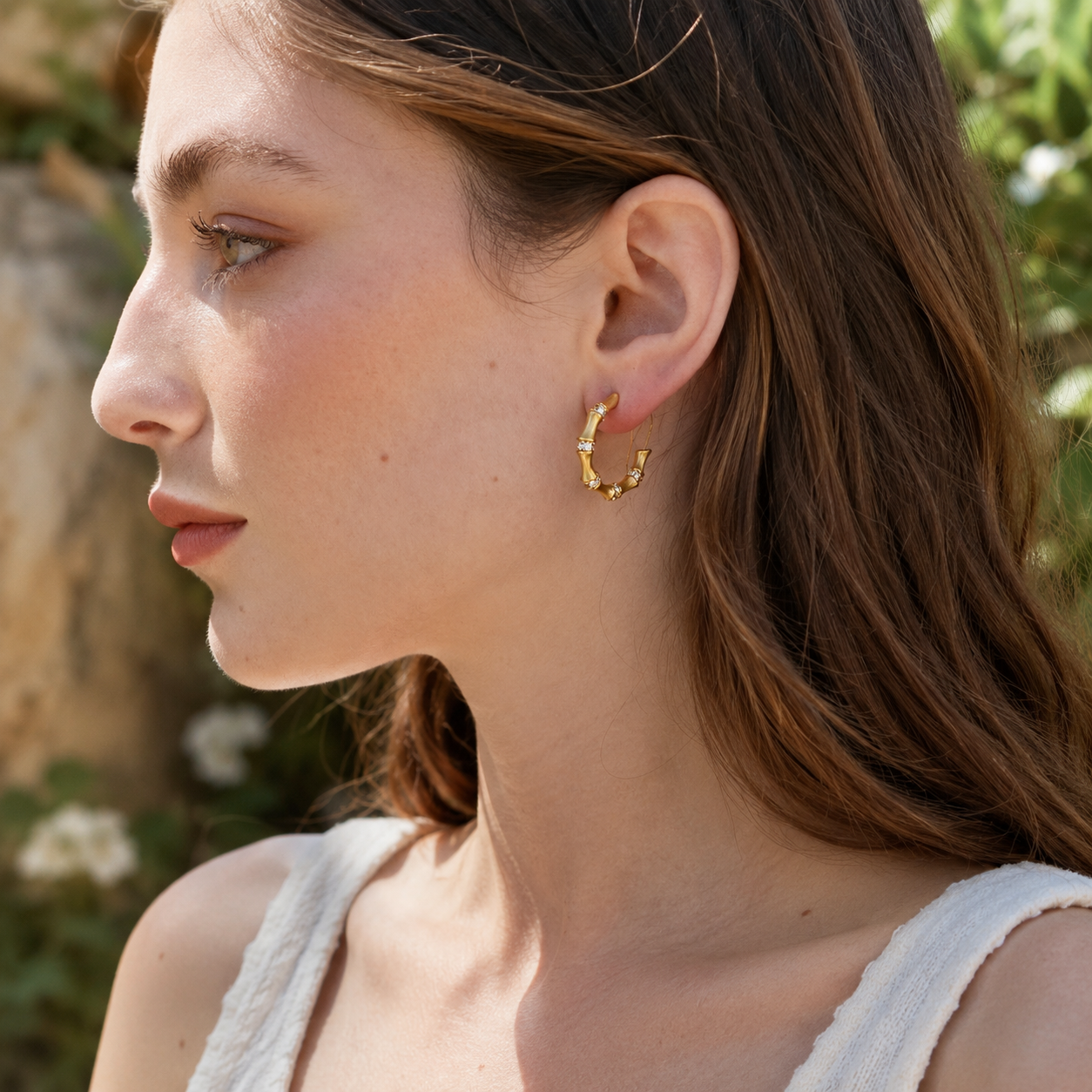 Side profile of model wearing gold bamboo hoop earrings