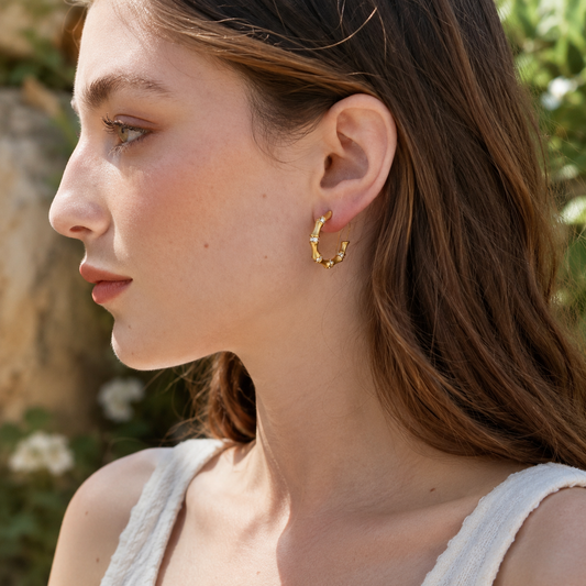 Side profile of model wearing gold bamboo hoop earrings