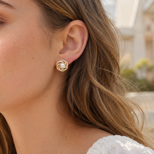 Close-up of model wearing gold pearl stud earrings