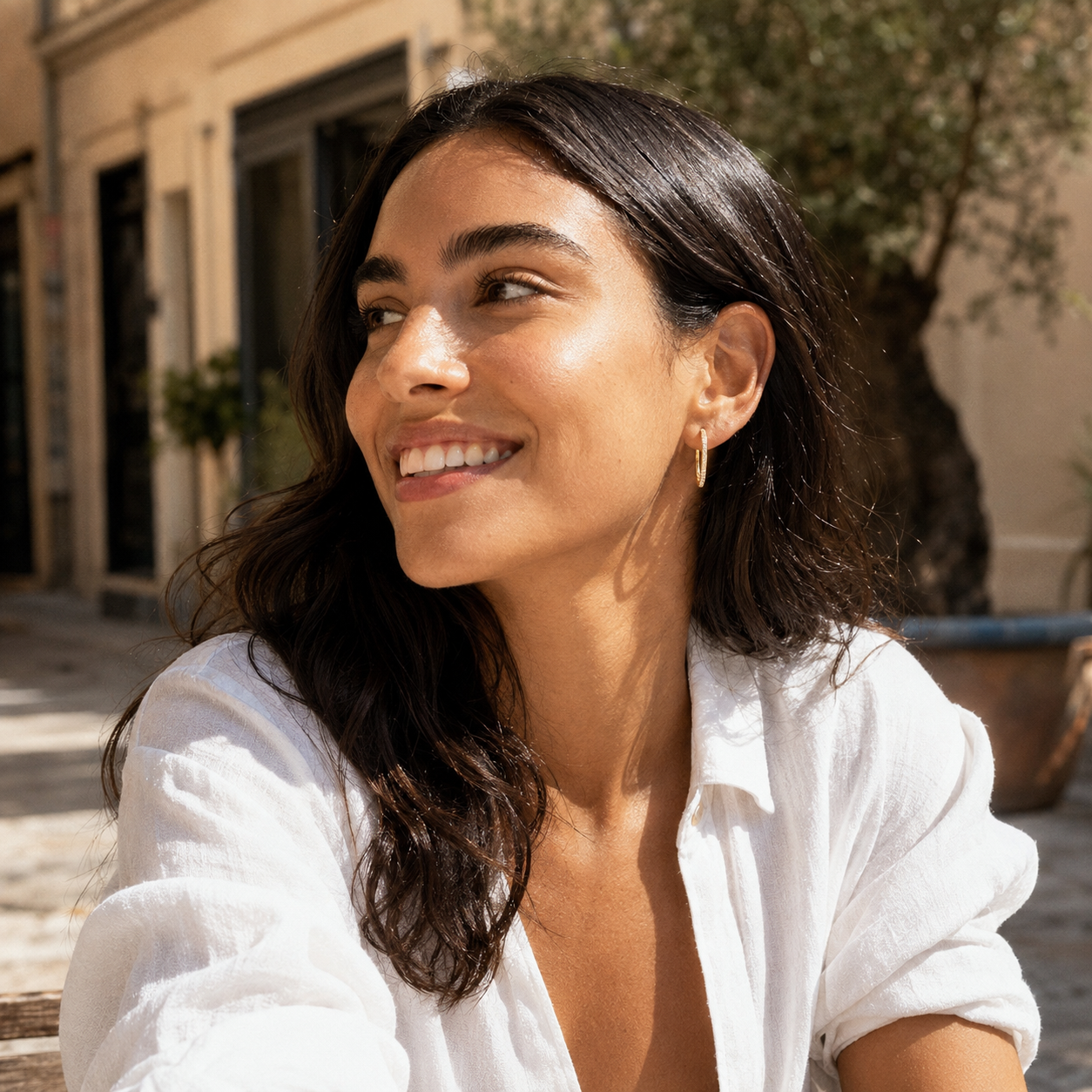 Model wearing gold Aurelia pavé hoops with a relaxed white shirt outdoors