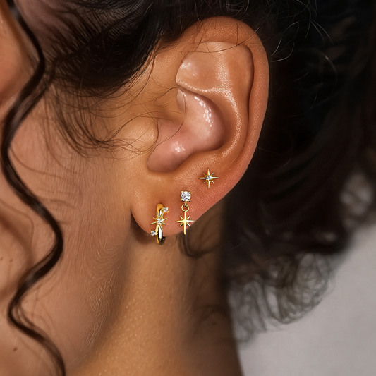 Celestial star stud, drop and huggie earrings on white display