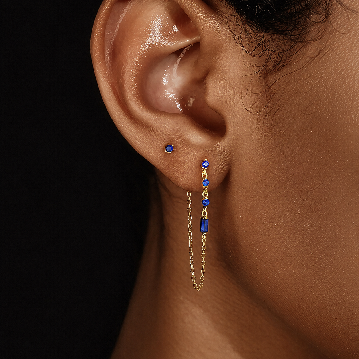 Close-up of model wearing a blue cubic zirconia chain drop earring