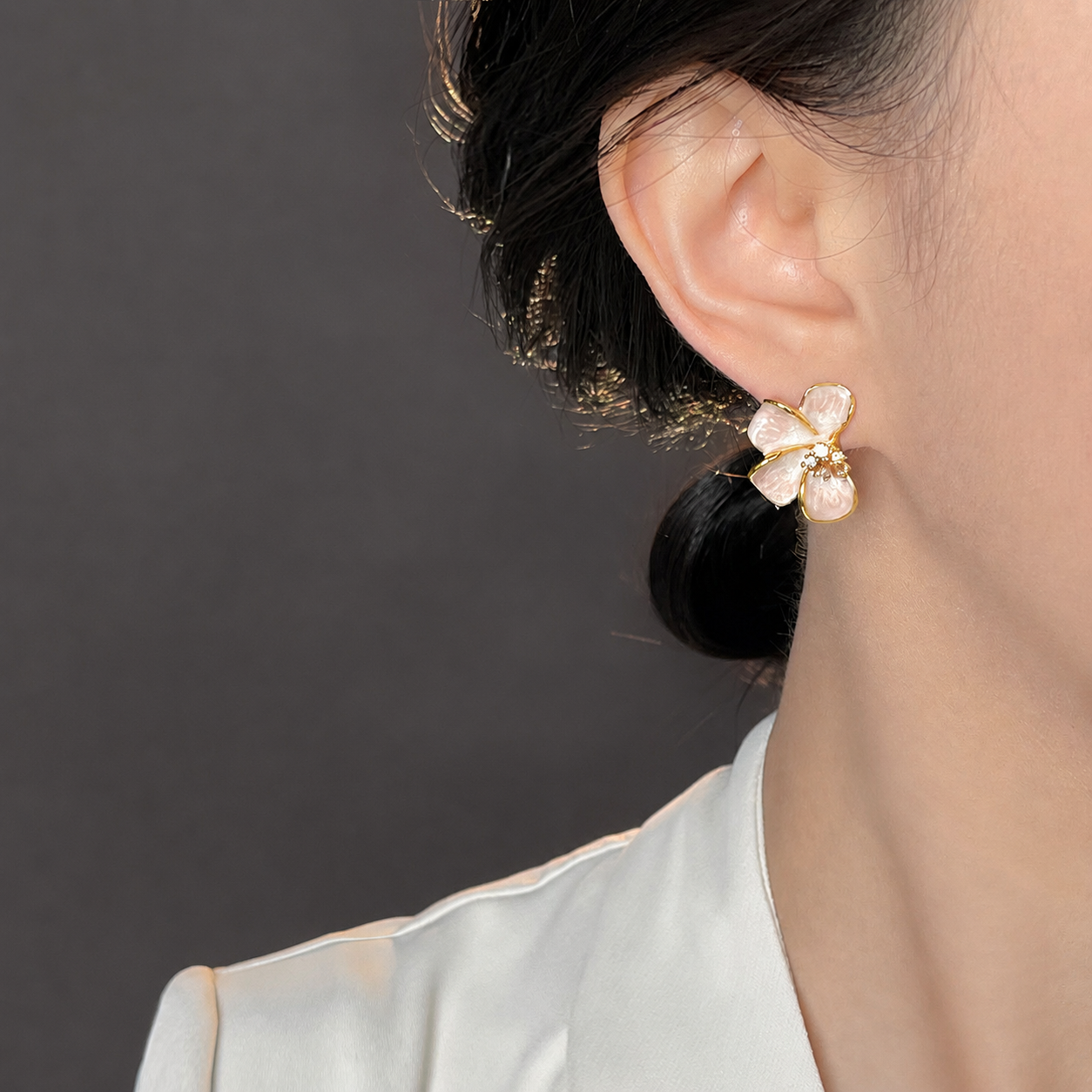 Rosalie Pink Blossom Stud Earrings worn on a dark-haired model with a white top