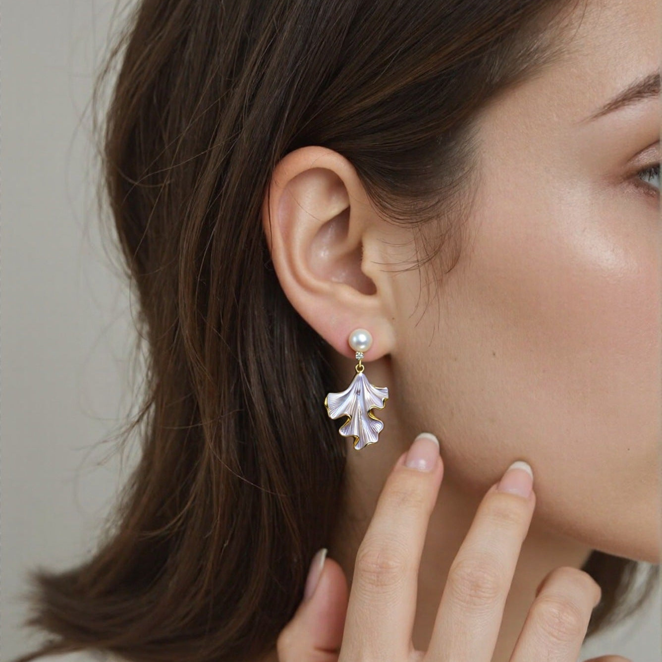 Model wearing Liora Pearl Ginkgo Drop Earrings with freshwater pearl studs and sculpted ginkgo-inspired drops