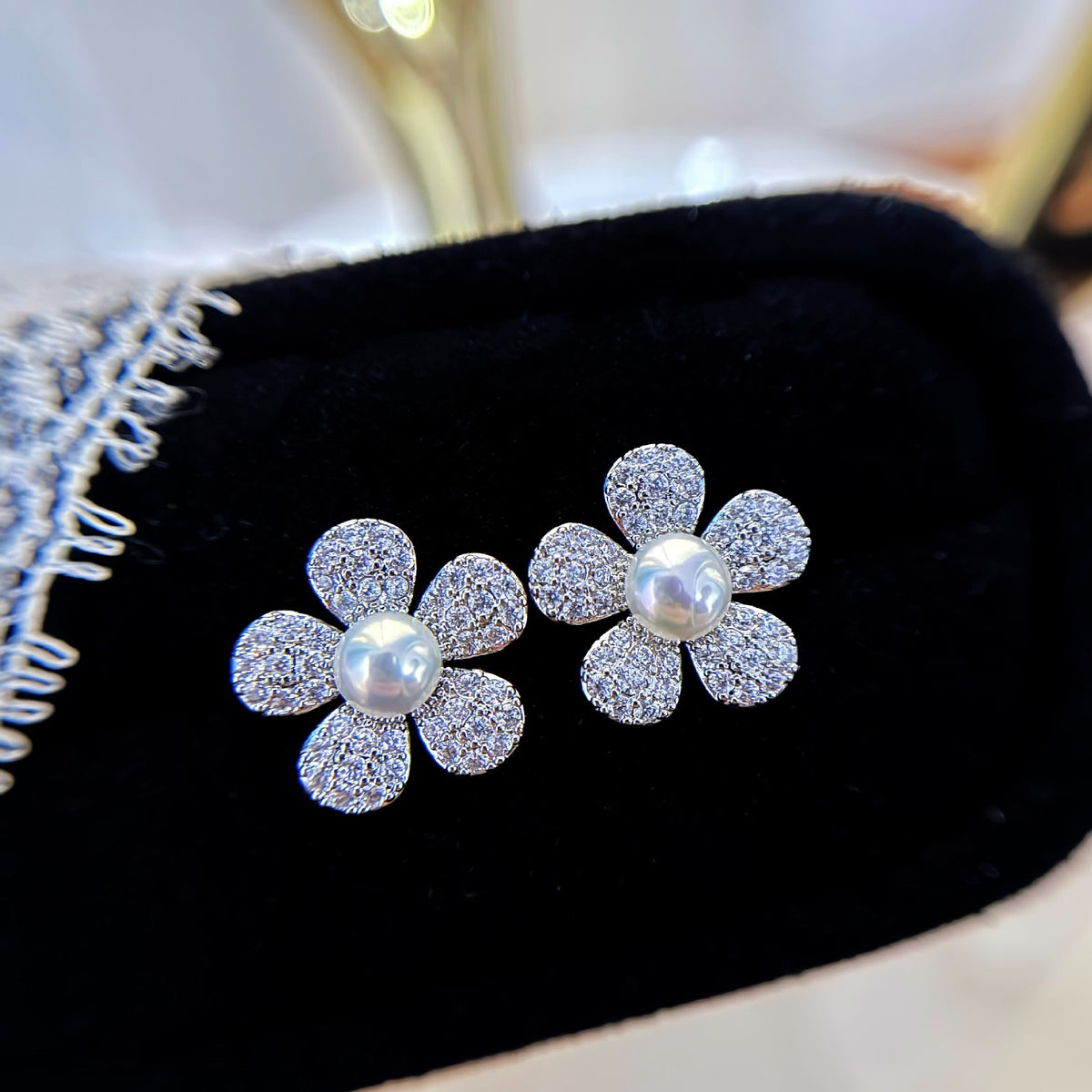 Pair of Marielle Pearl Flower Stud Earrings with freshwater pearl centres displayed on black velvet