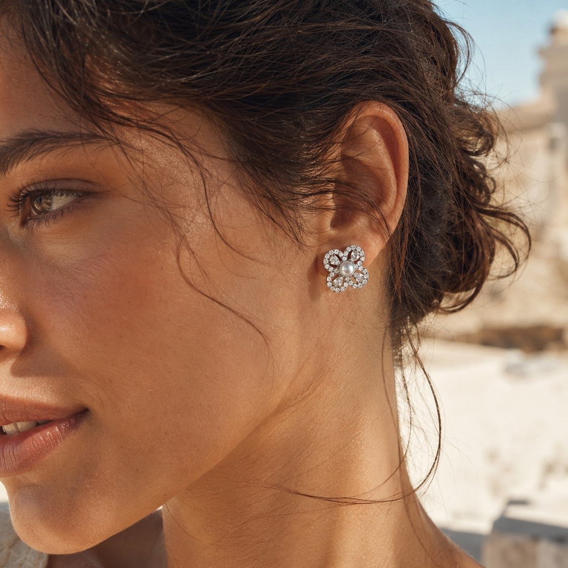 Model wearing Aurelia Pearl Clover Stud Earrings in warm natural sunlight