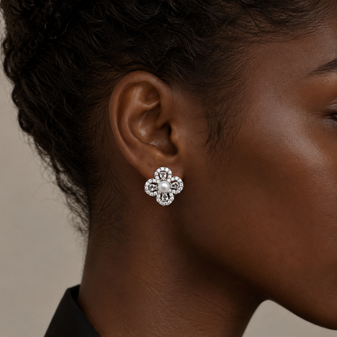 Close-up of a model wearing Aurelia Pearl Clover Stud Earrings with a black outfit