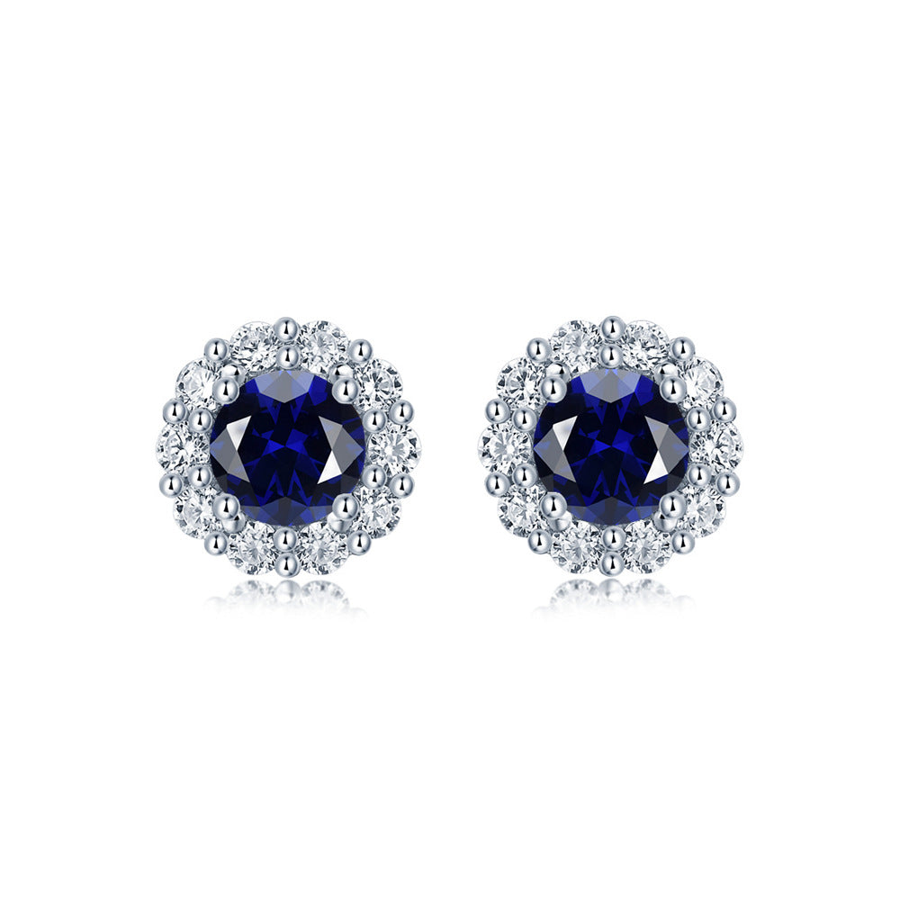 Elegant blue sapphire and diamond halo stud earrings in sterling silver, luxury fine jewelry by Aeterna Jewelry, product photo on white background