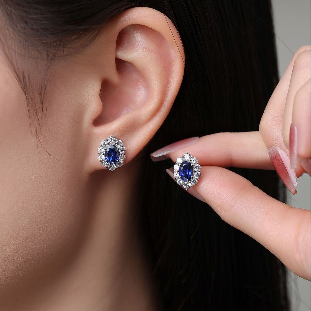 Woman wearing 2 carat sapphire and diamond halo stud earrings – elegant blue gemstone jewellery by Aeterna Jewellery UK