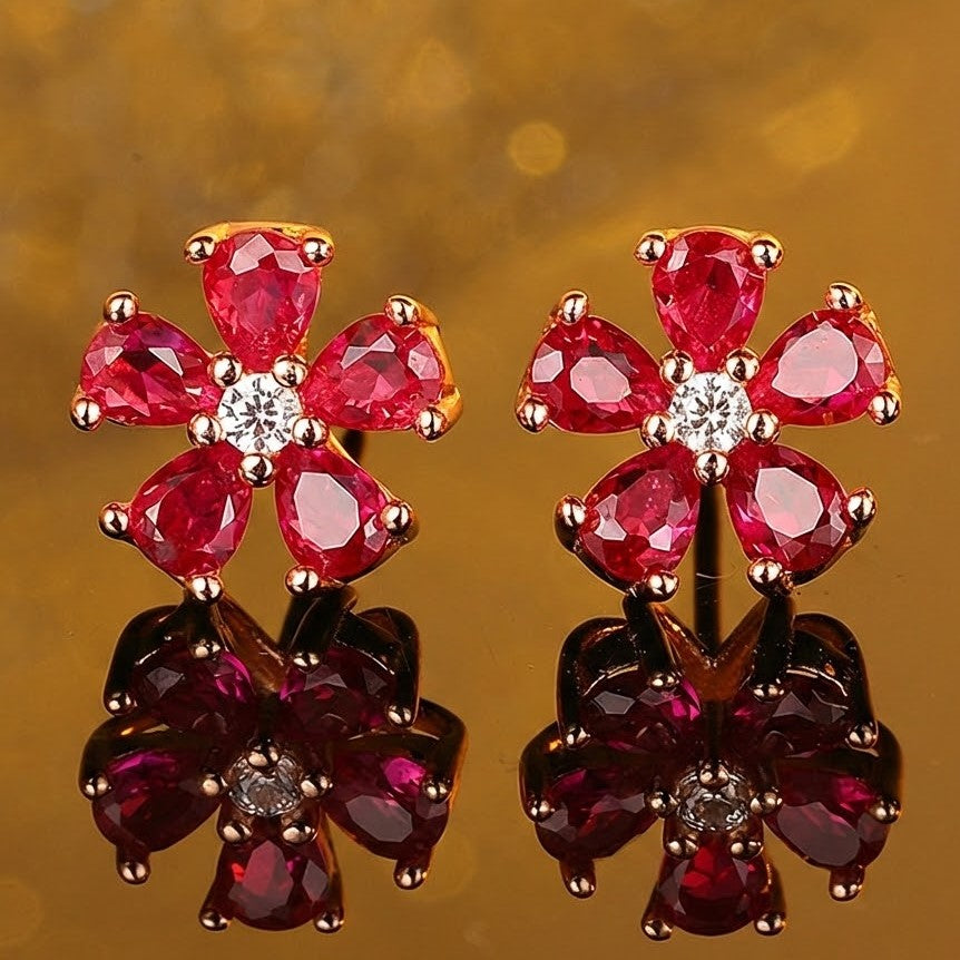 Garnet flower stud earrings with rose gold setting and sparkling centre stone on reflective surface