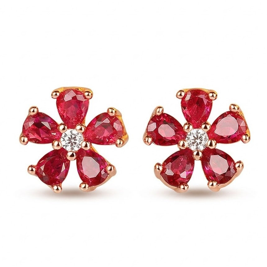 Red garnet flower stud earrings with polished rose gold prongs on white background