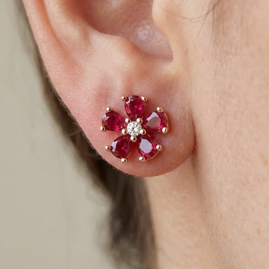 Garnet flower stud earrings worn on ear showing delicate petal design and gemstone sparkle