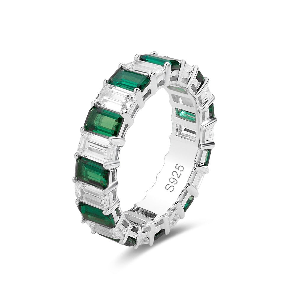 Emerald and white stone eternity band ring in sterling silver, geometric baguette-cut design, fine jewelry by Aeterna Jewelry, white background product photo