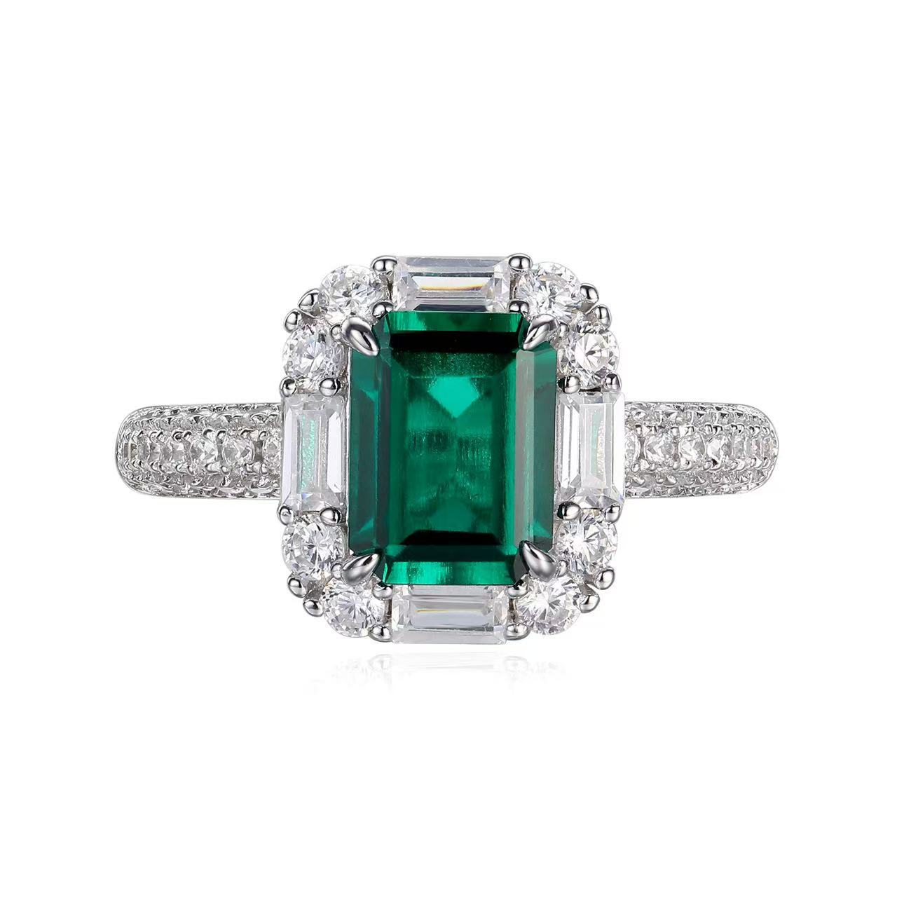 Aeterna Jewelry emerald-cut green gemstone ring with halo of white stones on white background