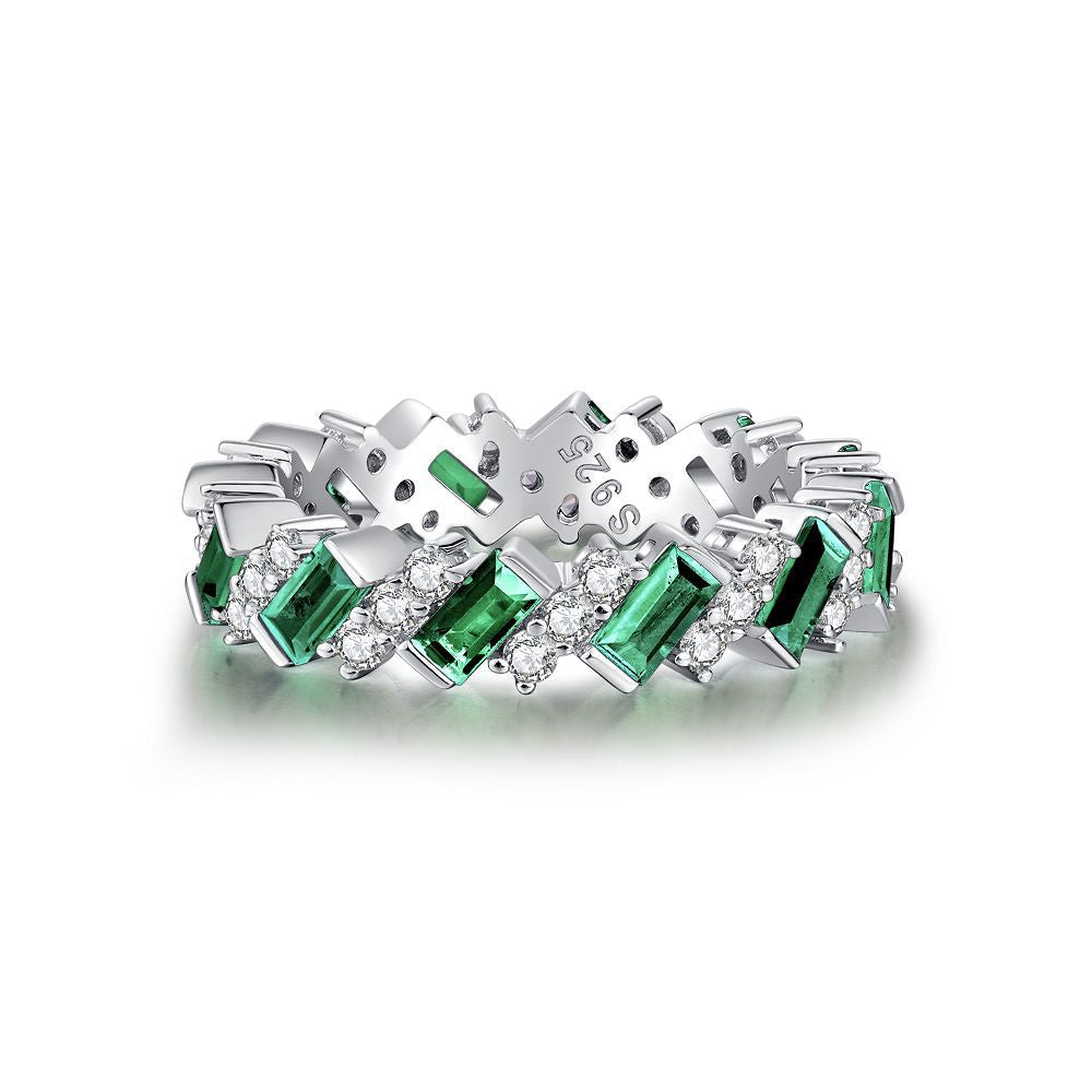 Aeterna Jewelry sterling silver eternity ring with alternating emerald and white stones on white background