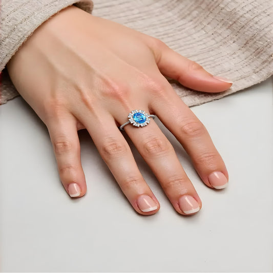 Model wearing Aeterna Jewelry aquamarine halo ring on hand, showing serene blue brilliance and elegant sparkle