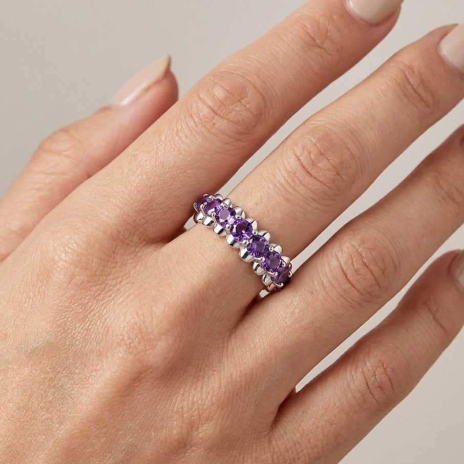 Amethyst eternity ring worn on hand in sterling silver