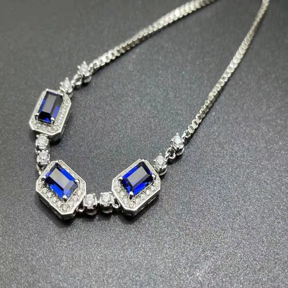 Close-up of sapphire trio bracelet showing deep blue emerald-cut stones