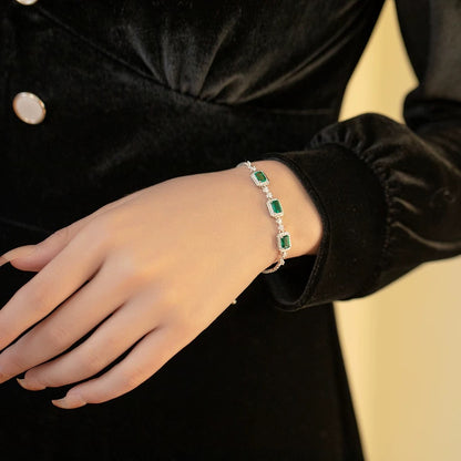Woman wearing emerald trio bracelet with black velvet dress