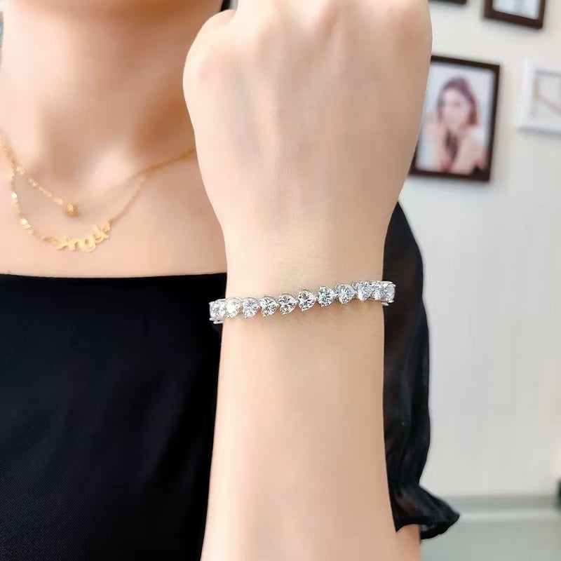 Elegant woman styling heart cut tennis bracelet with black dress