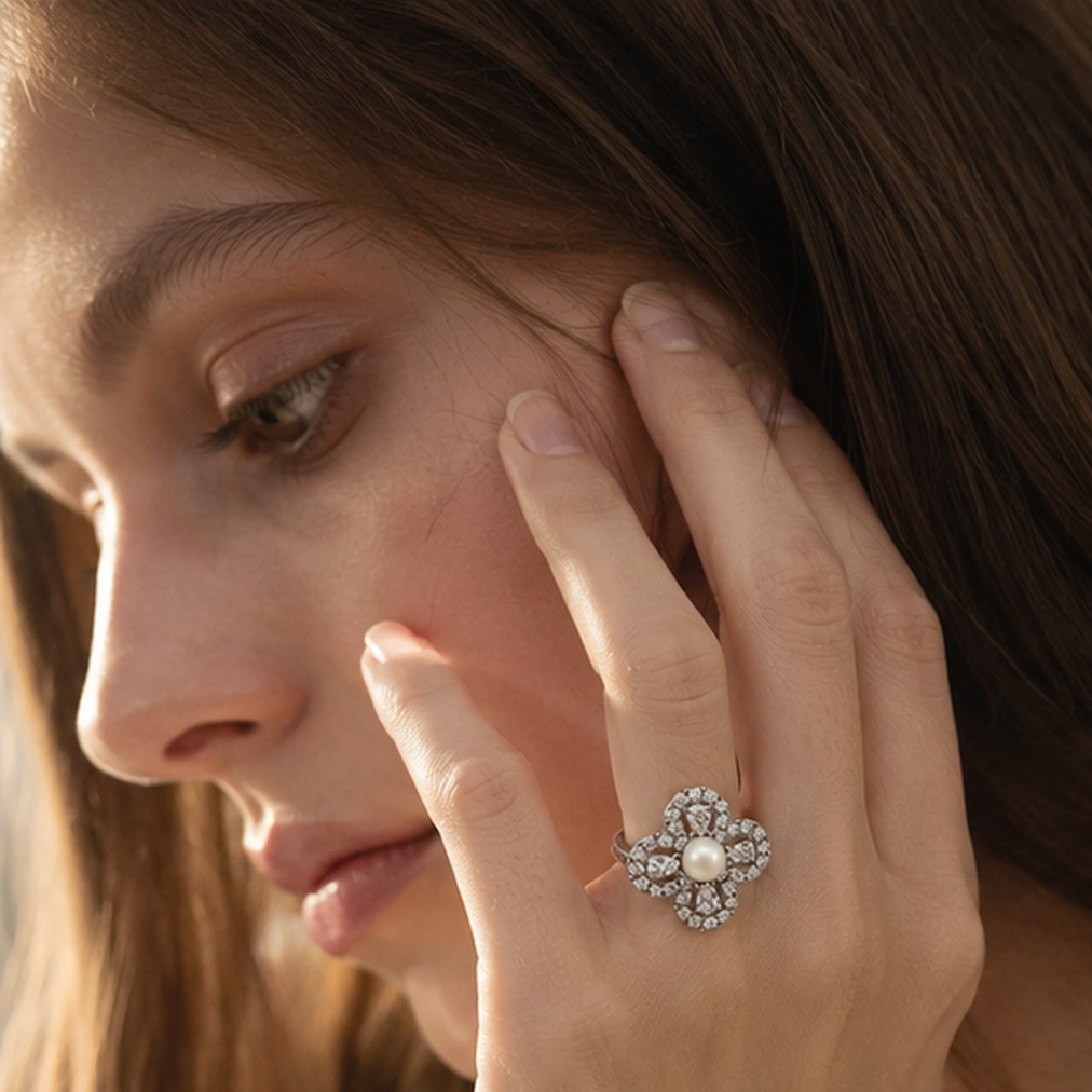 Close-up of Aurelia Pearl Clover Statement Ring worn beside the face in warm natural light